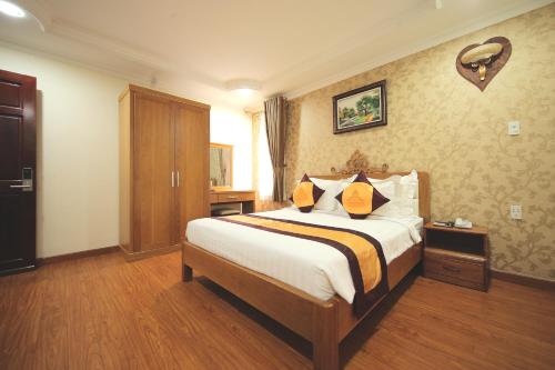 a hotel room with a bed with yellow pillows at Air Star Hotel in Ho Chi Minh City