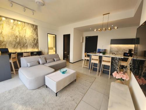 Urban Suites - Penang في Jelutong: غرفة معيشة مع أريكة وطاولة