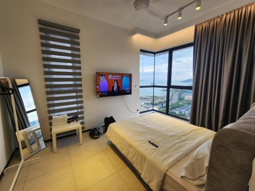 a bedroom with a bed and a flat screen tv at Urban Suites - Penang in Jelutong