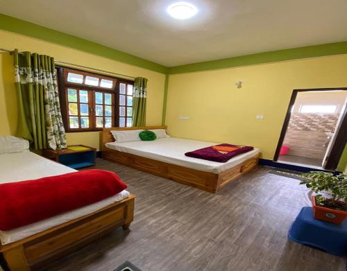 a bedroom with two beds and a window at Golden Apple Garden Homestay by StayApart in Kalimpong