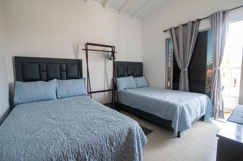 a bedroom with two beds and a window at Casa Bita Morales CASA 201 in Cartagena de Indias