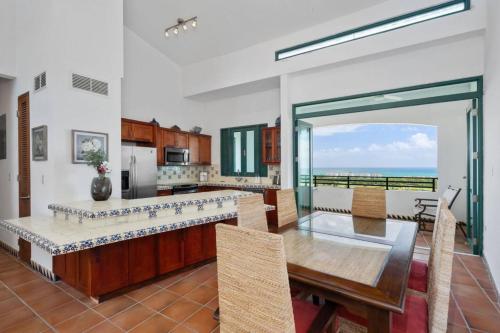 a kitchen with a dining table and a view of the ocean at Ocean View 4Bd Penthouse Wyndham Spectacular View near El Yunque Forest in Rio Grande