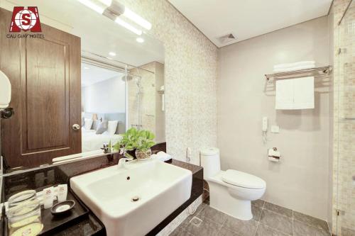 La salle de bains est pourvue d'un lavabo blanc et de toilettes. dans l'établissement Cầu Giấy Hotel -110 đường Cầu Giấy - by Bay Luxury, à Hanoï