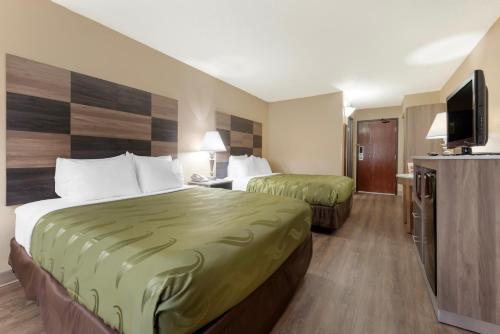 a hotel room with two beds and a flat screen tv at Quality Inn Bemidji in Bemidji