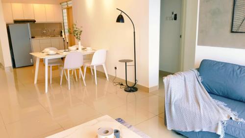 a living room with a table and a blue couch at Kulai d putra suites beside ioiMall near JPO and Airport in Kulai