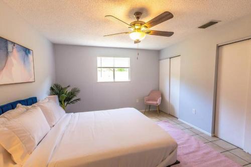 1 dormitorio con cama blanca y ventilador de techo en King beds, sports teams, work crews, en Sarasota