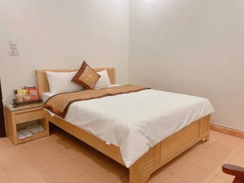 1 dormitorio con cama y mesita de noche en Hương Quê - 7 Ngõ Ga, Phú Lương, Hà Đông - by Bay Hostel, en Hà Ðông