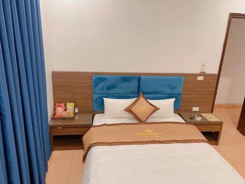 a bedroom with a large bed with a blue headboard at Hương Quê - 7 Ngõ Ga, Phú Lương, Hà Đông - by Bay Hostel in Hà Ðông