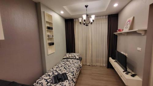 a small bedroom with a bed and a television at The Blu X Bangsaen F5 R51 in Ban Bang Saen (1)