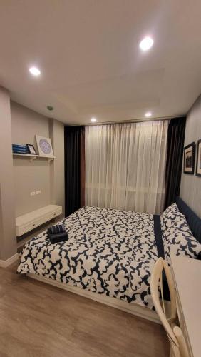 a bedroom with a bed with a black and white blanket at The Blu X Bangsaen F5 R51 in Ban Bang Saen (1)