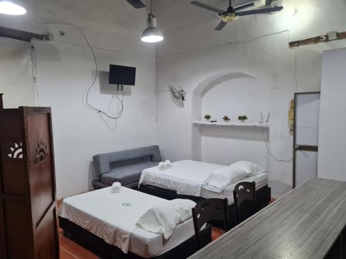 una habitación de hospital con 2 camas y una silla en Casa Faccioli, en Mompox