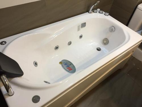 a white bath tub sitting in a bathroom at Thủ Đô Vàng Hotel - QL6 Hà Đông - by Bay Luxury in Hà Ðông