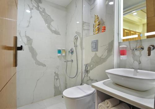 a white bathroom with a sink and a shower at Hotel Gold Palace - 03 Mins Walk From New Delhi Railway Station in New Delhi