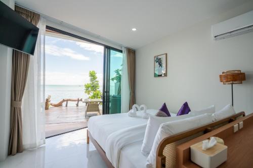 a bedroom with a bed and a view of the ocean at BeachHouse Pool Villas Krabi in Krabi town