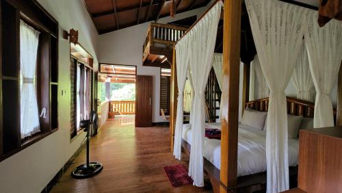 1 dormitorio con 2 camas con cortinas en Sam's Bungalows en Bukit Lawang