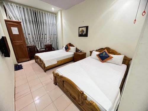 um quarto de hotel com duas camas e uma janela em Tuấn Anh - Số 62 ngõ 72 Nguyễn Trãi - by Bay Hostel em Hanói