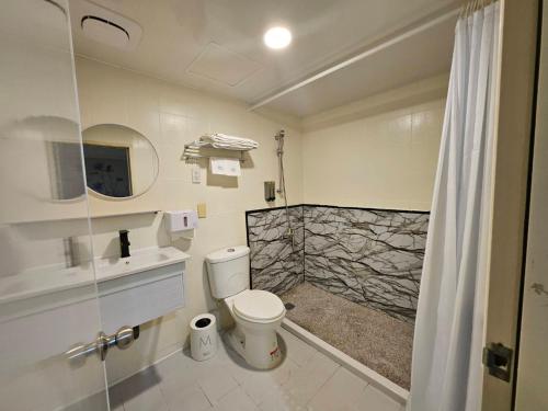 a bathroom with a toilet and a sink and a shower at Joy Garden Hotel in Kaohsiung