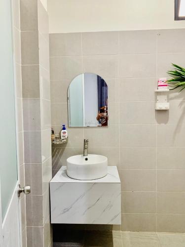 a bathroom with a white sink and a mirror at Homestay KV in Can Tho