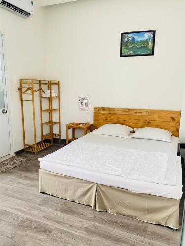a bedroom with a large bed with a wooden headboard at Homestay KV in Can Tho