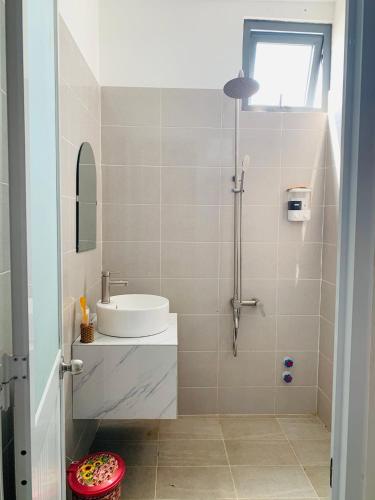La salle de bains est pourvue d'un lavabo et d'une douche. dans l'établissement Homestay KV, à Cần Thơ