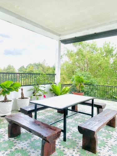a patio with two benches and a table at Homestay KV in Can Tho