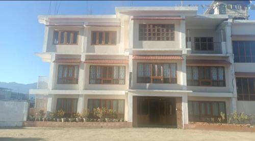 a large white building with a lot of windows at Hotel Tawang Inn in Tawang