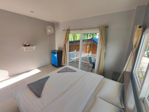 duże białe łóżko w pokoju z oknem w obiekcie Moon Travel Phangan w mieście Ban Nua