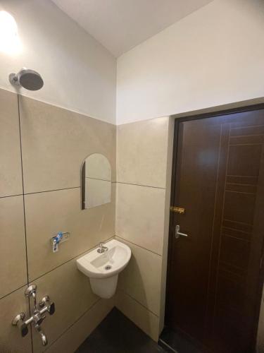 a bathroom with a toilet and a sink and a door at Royal residency in Tindummal
