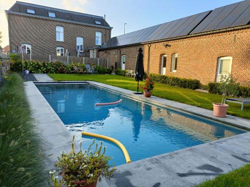 uma piscina no quintal de uma casa em B&B Het Doctershoes em Kinrooi