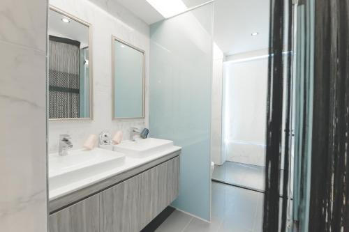 a white bathroom with two sinks and a mirror at Sunshine Palm B&B in Magong