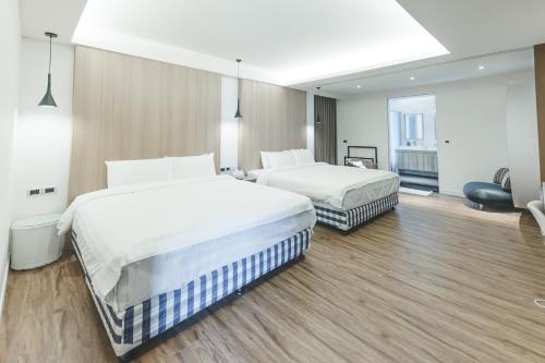 a hotel room with two beds and a chair at Sunshine Palm B&B in Magong