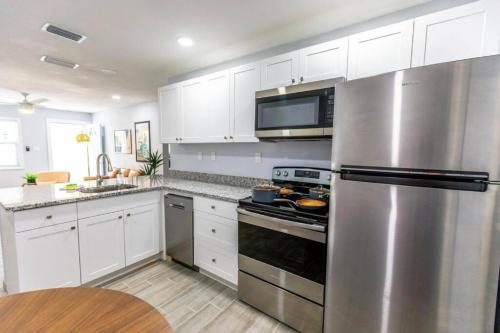a kitchen with white cabinets and a stainless steel refrigerator at Fenced backyard, near Downtown in Sarasota