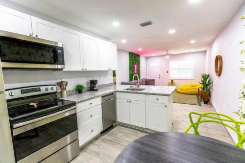 a kitchen with white cabinets and a table in it at Cocoanut neighborhood, king bed in Sarasota
