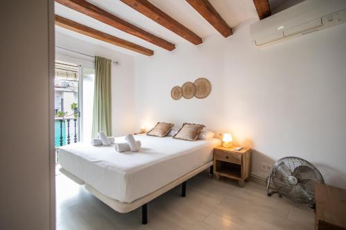 ein weißes Schlafzimmer mit einem Bett und einem Fenster in der Unterkunft 42enf1060 - Authentic &Centric Barcelonian 2BR flat in Barcelona