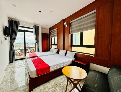 een hotelkamer met een bed en een bank bij OYO 1204 Hoang Linh Hotel in Da Lat