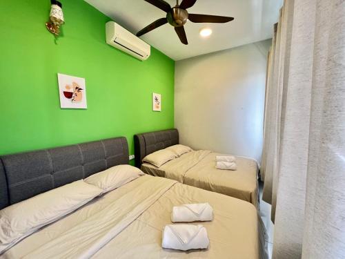 two beds in a room with a green wall at RiverView 8PAX 2BR in KBtown PS4, Netflix A-1-12 in Kota Bharu
