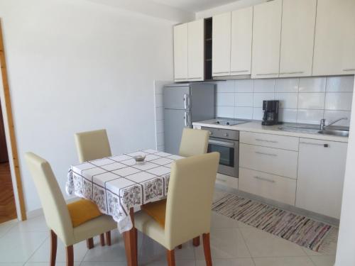 een keuken met een tafel en stoelen in een keuken bij Apartments Toncic in Lumbarda