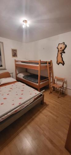StražaにあるApartma Ob Krkiのベッドルーム1室(二段ベッド2台、椅子付)