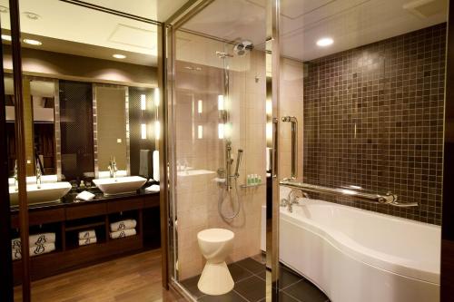 a bathroom with a shower and a tub and a sink at Kyoto Brighton Hotel in Kyoto