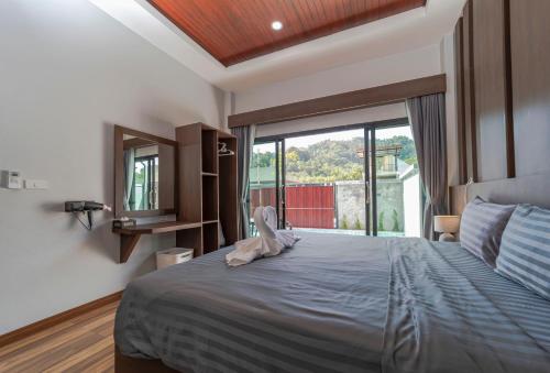 um quarto com uma cama grande e uma janela grande em N&D Poolvilla (1, 2, 3, 4) em Praia de Ao Nang