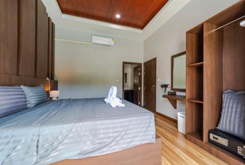 a bedroom with a large bed and a television at N&D Poolvilla in Ao Nang Beach