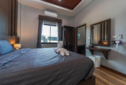 a bedroom with a bed with a stuffed animal on it at N&D Poolvilla in Ao Nang Beach
