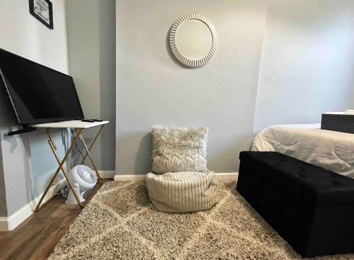 Private Comfy Room in Trendy Bed-Stuy في بروكلين: غرفة معيشة مع مرآة وكرسي