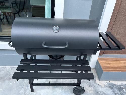 a grill sitting on a stand next to a door at N&D Poolvilla in Ao Nang Beach