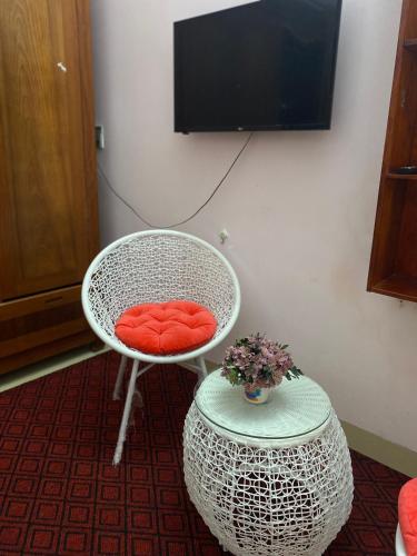 a white chair with a red cushion next to a table at Wind's House Ha Giang in Ha Giang