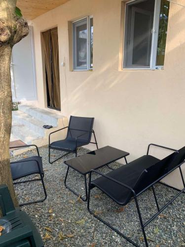 a group of chairs and tables next to a building at Cozy apartment in Ureki in Ureki
