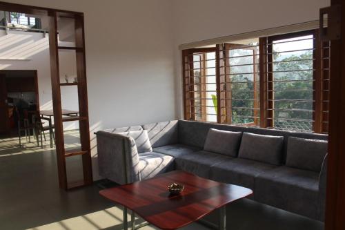a living room with a couch and a table at Grace villa in Piravam