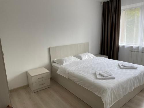 a bedroom with a bed with two towels on it at Hotel Palladium in Shchūchīnsk