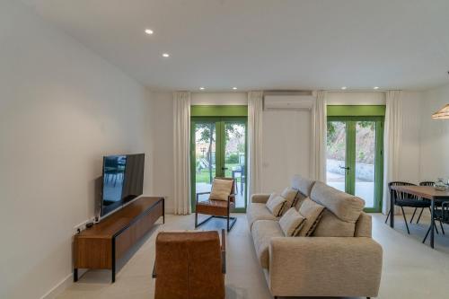 a living room with a couch and a tv at Paredones III Casa Rural Caminito del Rey in Alora