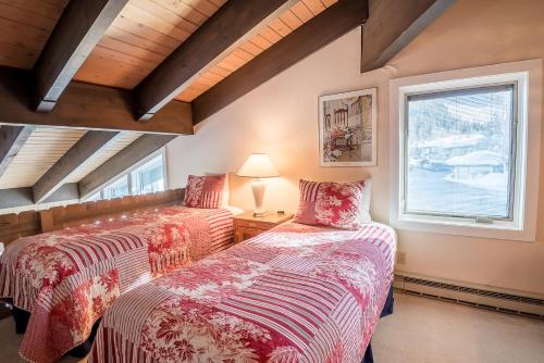 een slaapkamer met 2 bedden en een raam bij Prospector 171 - Walk to Ski Lifts and Hot Tub for Apres Ski in Ketchum